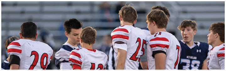 A group of football players on a field. Description generated by AI