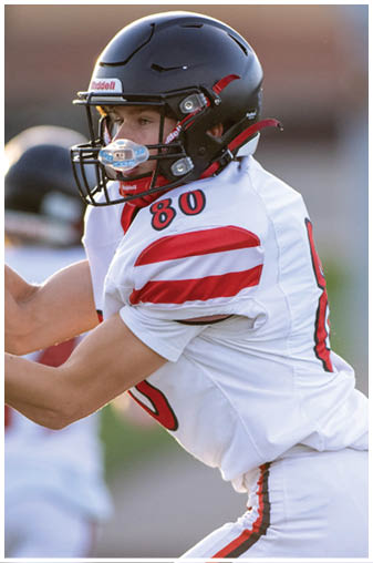 A football player wearing a black and white jersey with the number 5 on it. Description generated by AI
