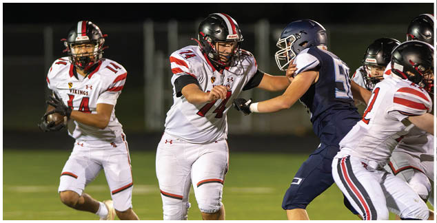 A football player in a black jersey is running with the ball. Description generated by AI