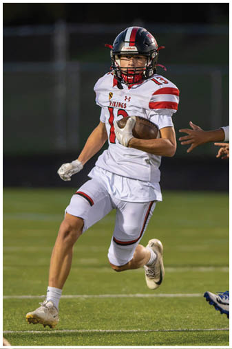 A football player wearing a black and white jersey with the number 5 on it. Description generated by AI