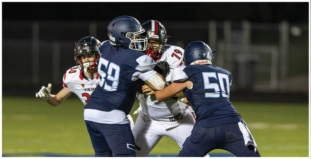 A football player in a yellow jersey is tackled by another player. Description generated by AI