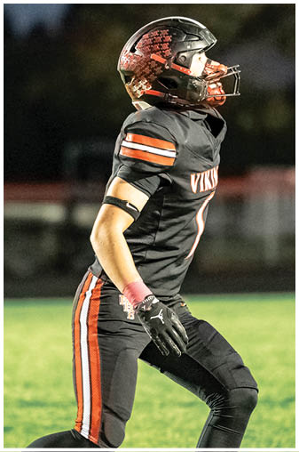 A football player in a black jersey with the number 6 on it. Description generated by AI