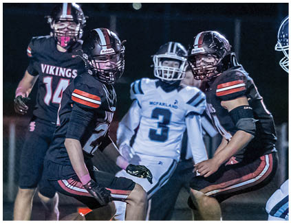 A football player wearing a black and white jersey with the number 12 on it. Description generated by AI