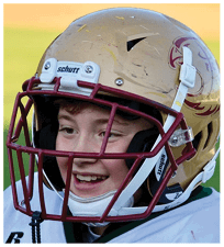 A person wearing a gold football helmet with a maroon faceguard and a logo on the side is visible from the eyes up. Description generated by AI