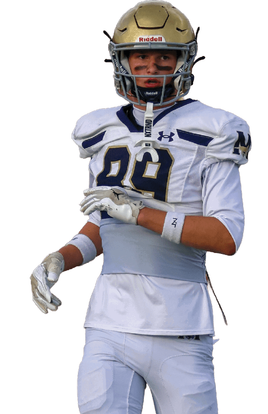 A person wearing a white football uniform with the number 29 and a gold helmet is standing and looking forward. Description generated by AI