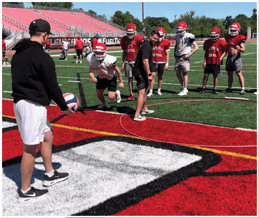 A group of football players wearing black and white uniforms. Description generated by AI