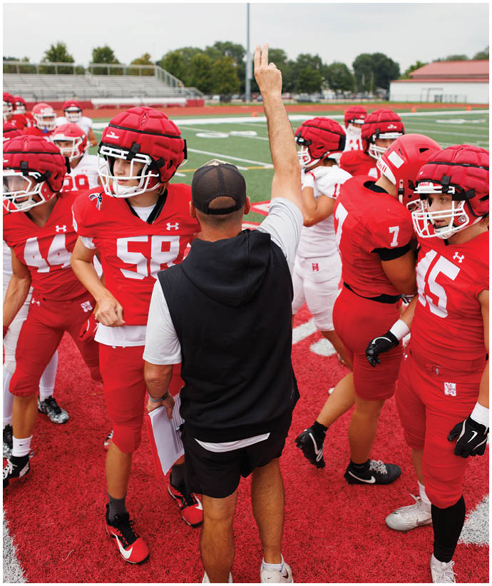 A group of football players wearing black and white uniforms. Description generated by AI