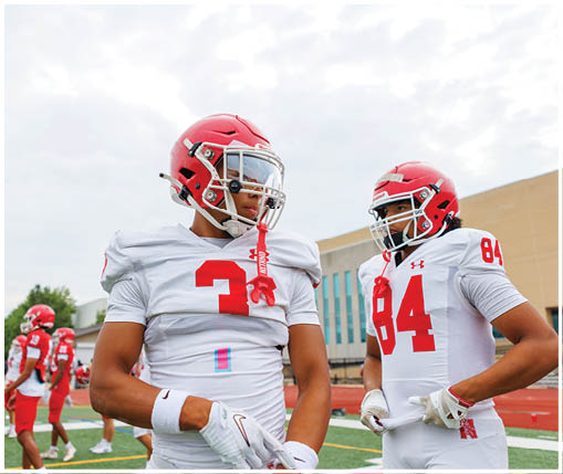 A group of football players wearing black and white uniforms. Description generated by AI