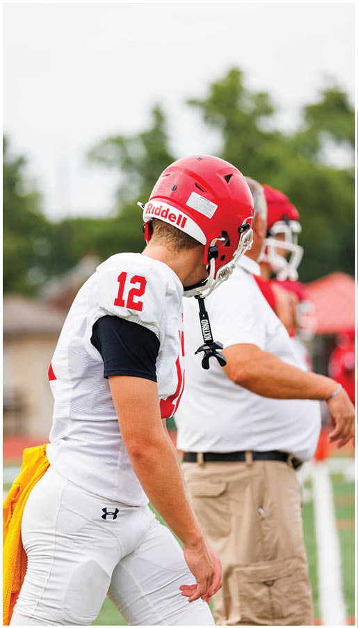 A group of football players wearing black and white uniforms. Description generated by AI
