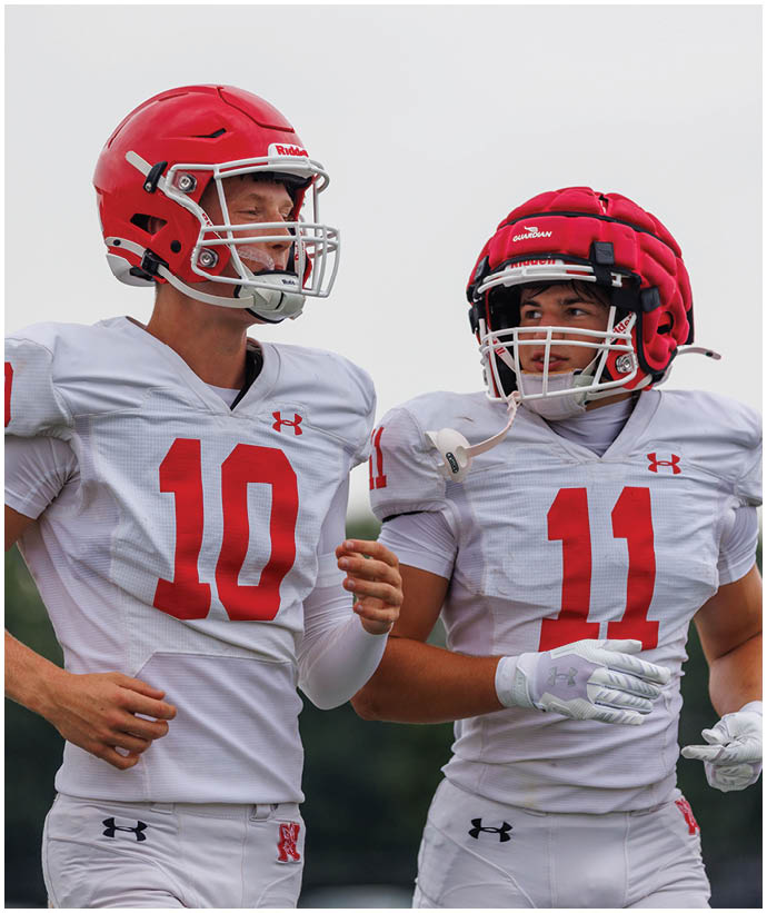 A group of football players wearing black and white uniforms. Description generated by AI