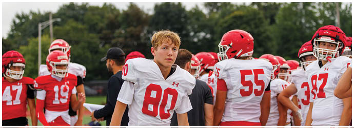A group of football players on a field. Description generated by AI