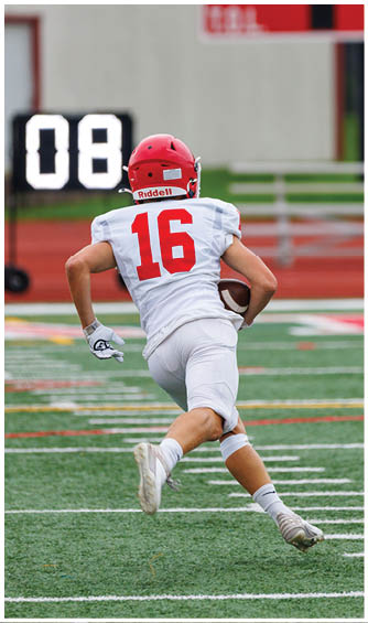 A football player running on the field. Description generated by AI