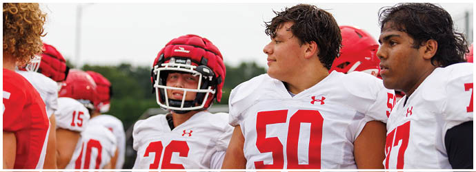A group of football players on a field. Description generated by AI