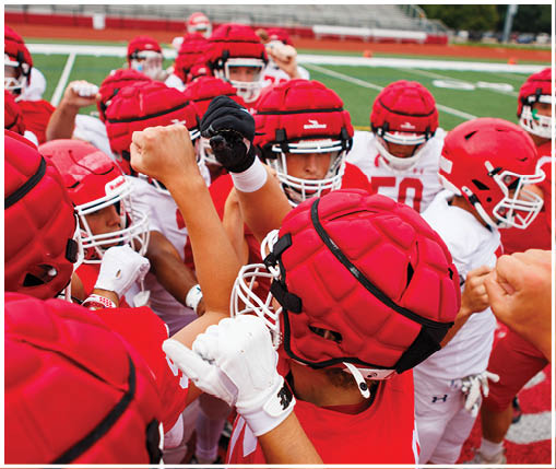 A group of football players wearing black and white uniforms. Description generated by AI