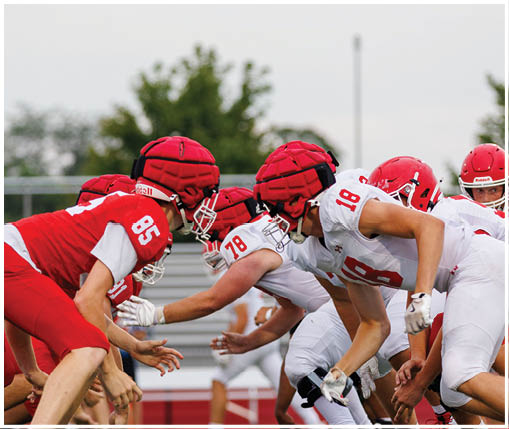 A group of football players wearing black and white uniforms. Description generated by AI