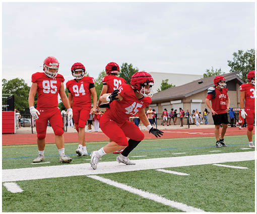 A group of football players wearing black and white uniforms. Description generated by AI