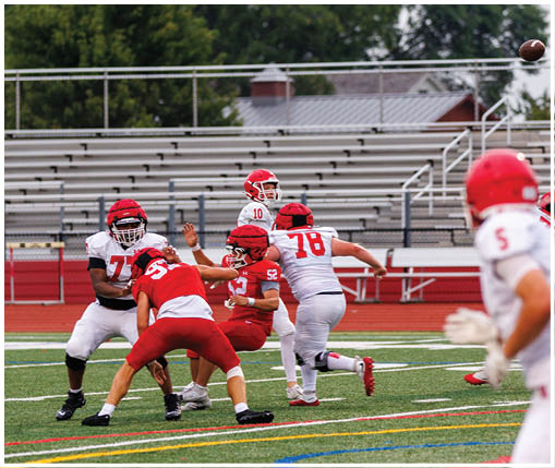 A group of football players wearing black and white uniforms. Description generated by AI