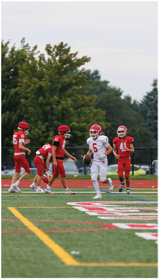 A group of football players wearing black and white uniforms. Description generated by AI