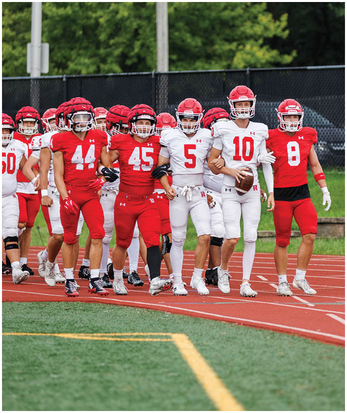 A group of football players wearing black and white uniforms. Description generated by AI