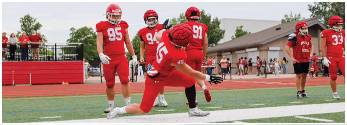 A group of football players on a field. Description generated by AI