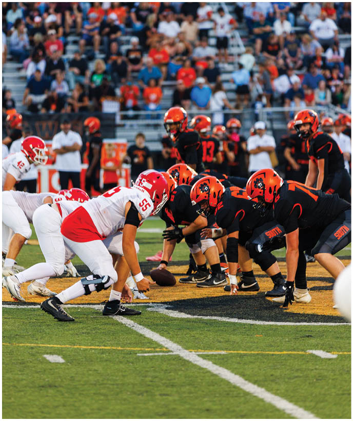A group of football players wearing black and white uniforms. Description generated by AI