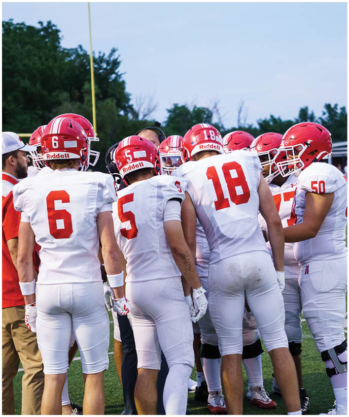 A group of football players wearing black and white uniforms. Description generated by AI