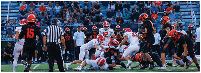 A group of football players on a field. Description generated by AI