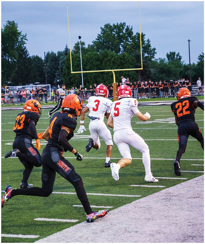 A group of football players wearing black and white uniforms. Description generated by AI