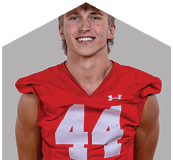 A young man wearing a white jersey with the number 10 on it. Description generated by AI