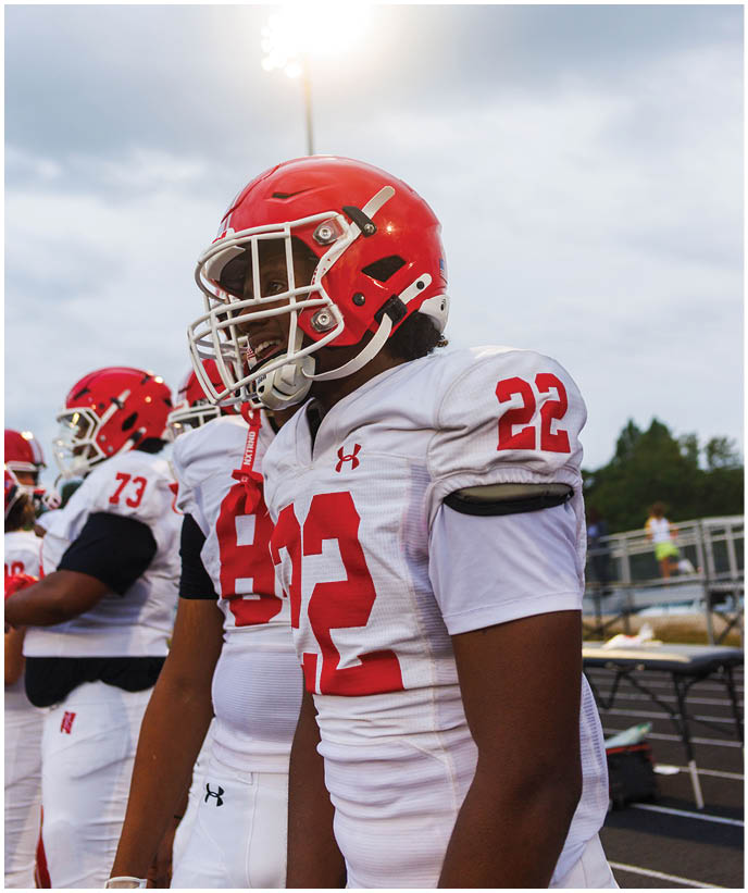 A group of football players wearing black and white uniforms. Description generated by AI