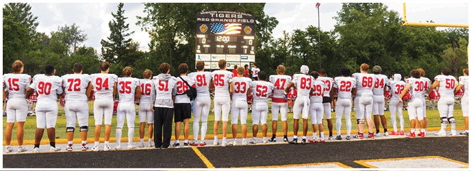 A group of football players on a field. Description generated by AI