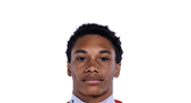 Person wearing a red sports jersey with the number four and a white undershirt standing against a plain gray background. Description generated by AI
