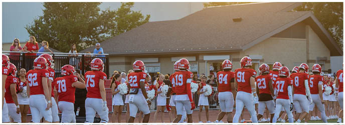 A group of football players on a field. Description generated by AI
