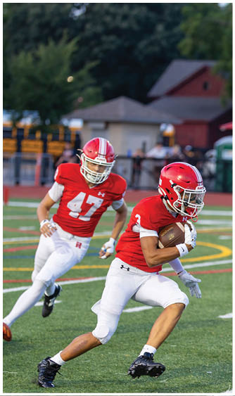 A football player running on the field. Description generated by AI