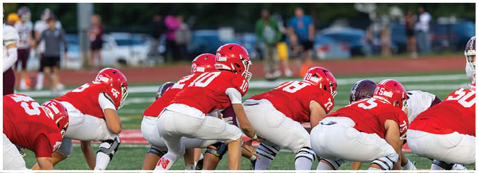 A group of football players on a field. Description generated by AI