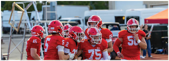 A group of football players on a field. Description generated by AI