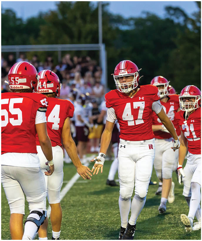 A group of football players wearing black and white uniforms. Description generated by AI