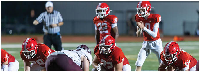 A group of football players on a field. Description generated by AI