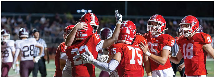 A group of football players on a field. Description generated by AI