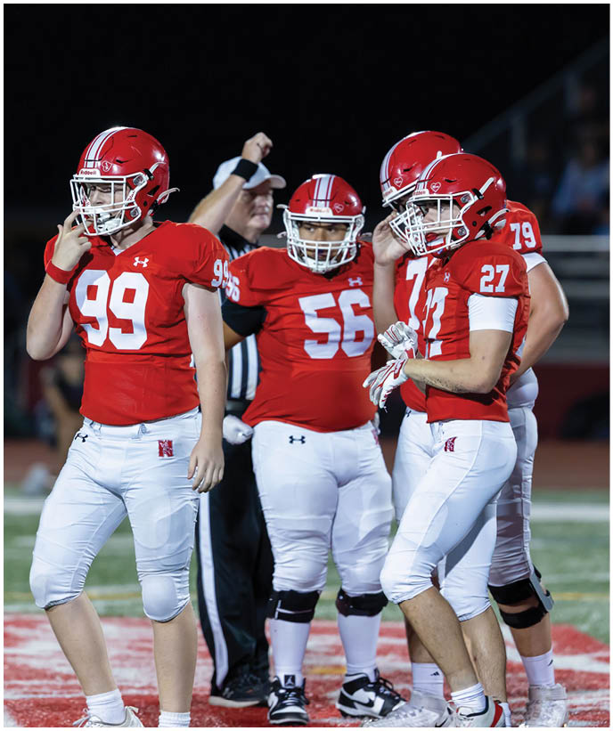 A group of football players wearing black and white uniforms. Description generated by AI