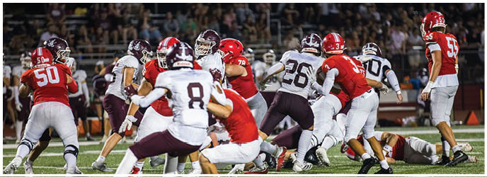 A group of football players on a field. Description generated by AI