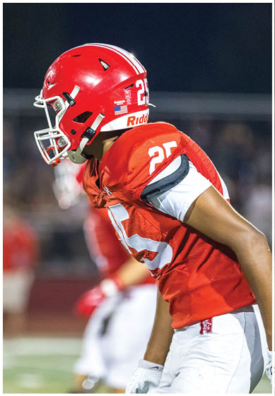 A football player wearing a blue jersey with the number 58 on it. Description generated by AI