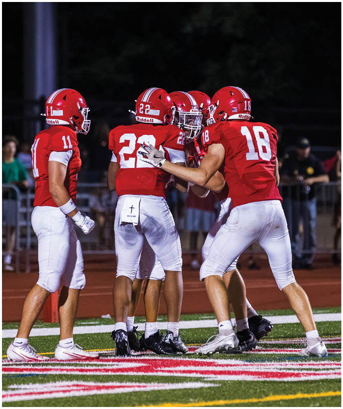 A group of football players wearing black and white uniforms. Description generated by AI