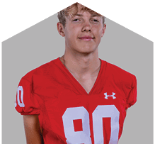 A young man wearing a white jersey with the number 10 on it. Description generated by AI