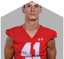 A young man wearing a white jersey with the number 10 on it. Description generated by AI