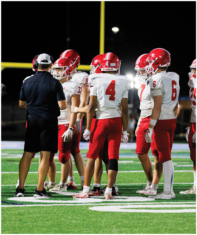 A group of football players wearing black and white uniforms. Description generated by AI