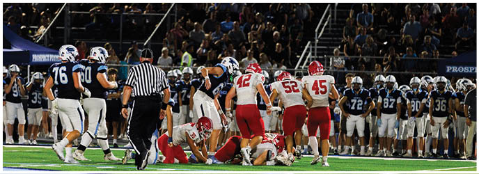 A group of football players on a field. Description generated by AI