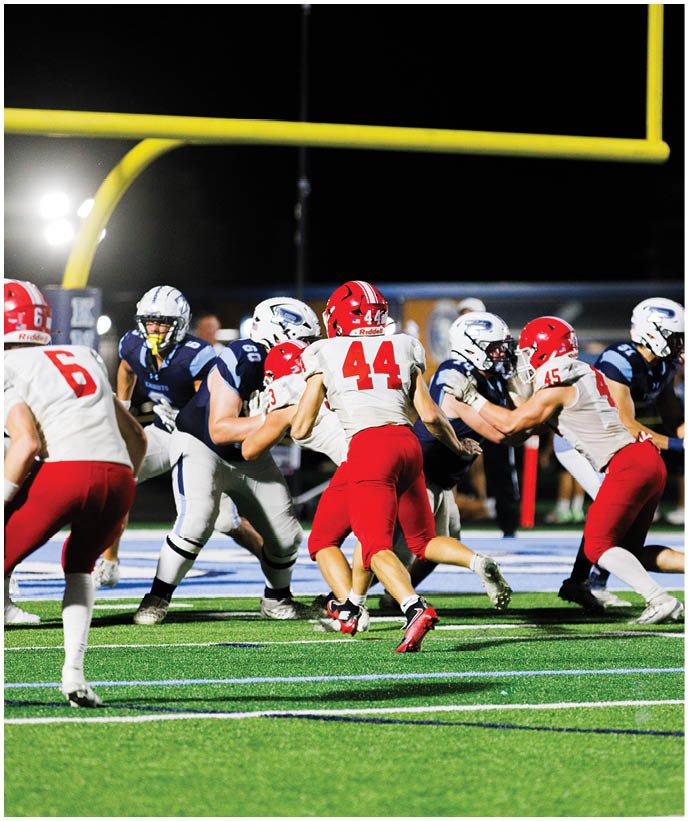 A group of football players wearing black and white uniforms. Description generated by AI