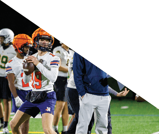 A group of football players kneeling on the field, some with their hands on their heads. AI generated content