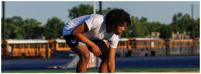 A football player wearing a blue and white uniform. Description generated by AI